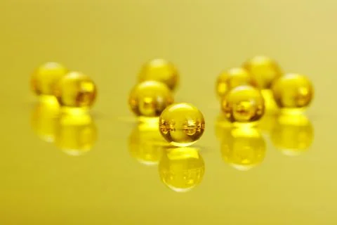 Macro of e vitamine capsules on yellow Stock Photos