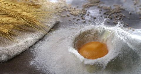 Macro of egg yolk put in wheat flour for preparation dough for homemade bread Stock Footage 268805757