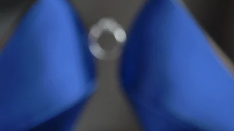 Macro engagement ring in between to blue heels move in Stock Footage 114369208