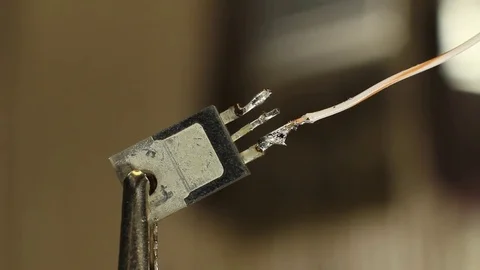 Macro - engineer soldering a wire to an electrical component Stock-Footage 85069832