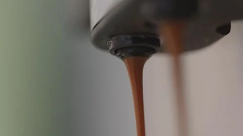 Macro of Espresso Pouring from Coffee Machine Spout Stockbeeldmateriaal 334877036