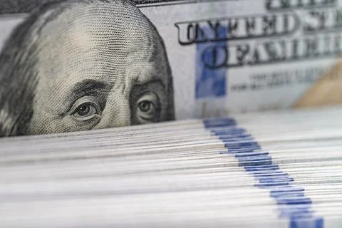 Macro extreme close up of Benjamin Franklin eyes on hundred dollar bill stack Stock Photos