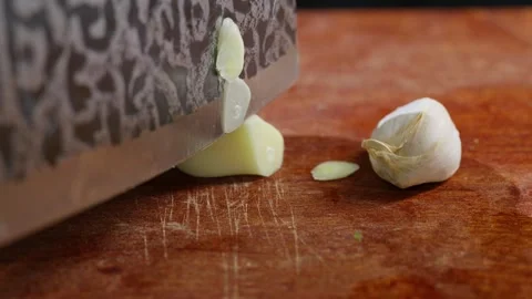Macro extreme close-up shot of garlic being sliced into thin flakes. 動画素材 341836488