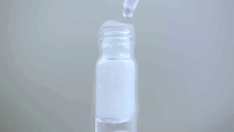 Macro eye dropper creates bubbling vile with smoke on white Stock Footage 70672436