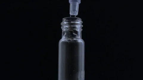 Macro eye dropper creates smoking vial on black BG Stock-Footage 70705883