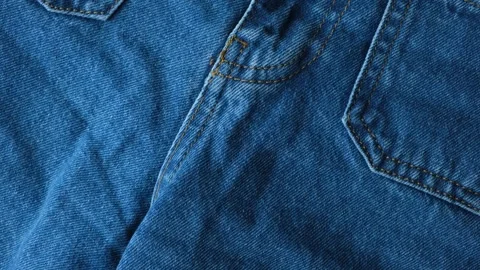 Macro fabric texture of cotton blue jeans. Pocket and thread stitching Stock Footage 310605364
