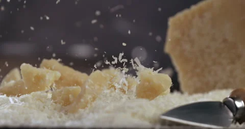 Macro of falling pieces of parmesan cheese pieces on wooden table in restaurant Stock Footage 269325723