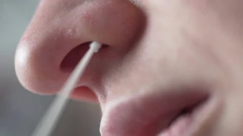 Macro filming, a woman does a rapid nasal swab test for covid-19 Stock Footage 165620699