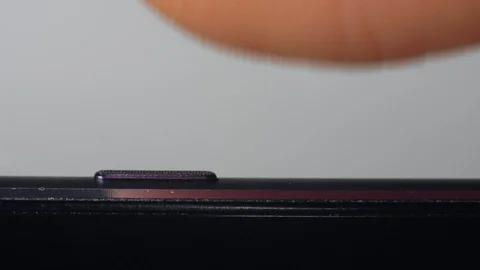 Macro, finger presses pushes power button to turn on or turn off the smartphone Stockbeeldmateriaal 129486708