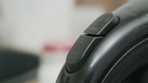 Macro of a finger pressing a button on black electronic device to turn it on Stock Footage 340406696