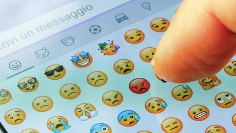 Macro finger scrolling emojis on a virtual keyboard Stock Footage 127446028
