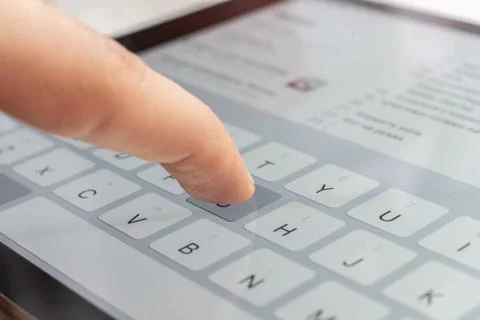 A macro of a finger typing text on the touch screen keyboard of mobile device Stock Photos