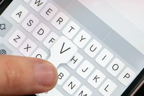A macro of a finger typing text on the touch screen keyboard of mobile device Stock Photos