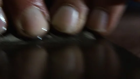 Macro fingertips pressing a blade across a sharpening stone Stock Footage 346254130