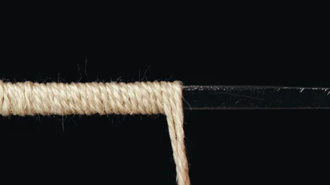 Macro Footage of Thick Thread Winding onto Metal Wire Stock Footage 253815417
