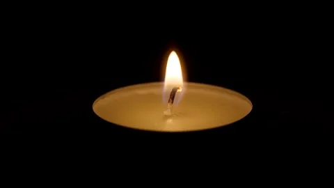Macro footage of tiny candle extinguishing after breath of air on dark Stock Footage 328521952