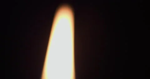 Macro footage of a top of a burning candle with a black background Vidéo 220141347