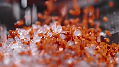 Macro frame of white and orange plastic granules. The polymer composite is Stock Footage 255975870