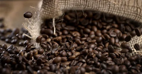 Macro of fresh aromatic roasted coffee beans falling on table in coffee shop Stock Footage 269323047