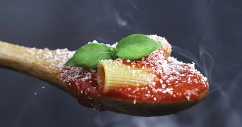 Macro of fresh basil leaf falling on tomato sauce with pasta and parmesan cheese Stock Footage 268880751