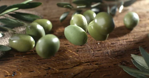 Macro of fresh bio olives falling on burlap sack harvested directly from trees Stock Footage 268459624
