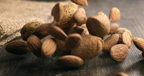 Macro of fresh bio organic dried almond nuts are falling on wooden table Stock Footage 268841503