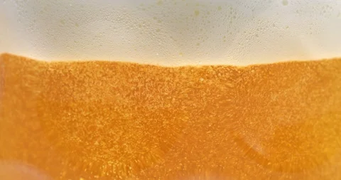 Macro of fresh brewed beer in cool transparent glass with white foamy froth Stock Footage 268417004