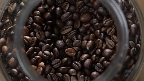 Macro fresh coffee beans falling into a jar good in reverse to create some magic Stock Footage 124123644