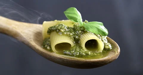 Macro of fresh green basil leaf falling on italian pasta with pesto sauce Stock-Footage 268880420