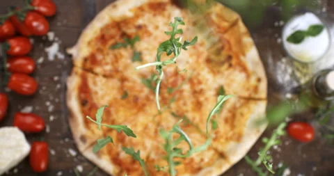 Macro of fresh green rocket leaves falling on italian dish of pizza margherita Stock Footage 268838265