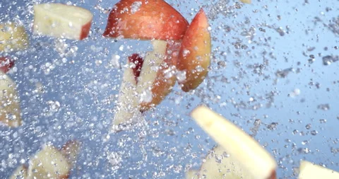 Macro of fresh ripe bio red apple fruit slices fly with splashing water drops Stock Footage 269930273