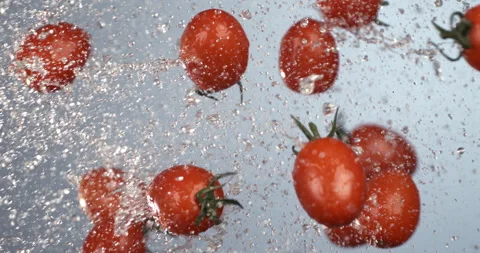 Macro of fresh ripe organic cherry tomatoes flying with splashing water drops Stock Footage 269926445