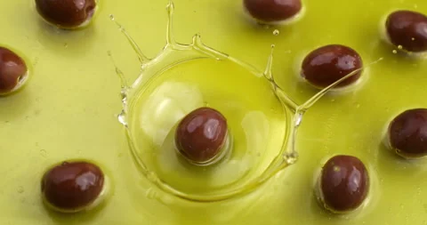 Macro of fresh ripe red olive falling in bio organic extra virgin olive oil Stock Footage 268803376
