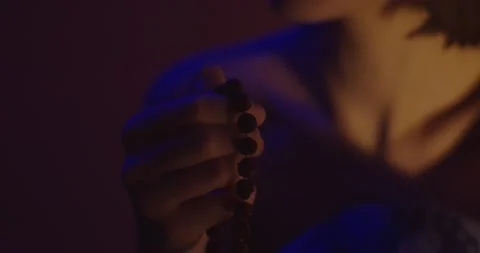 Macro front view of female hand holding beads for praying on shallow colorful Stock Footage 145628798
