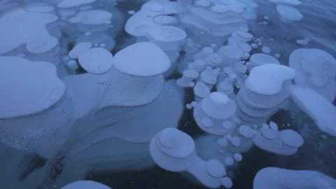 Macro frozen methane multilayered bubbles trapped in ice Lake Baikal, Siberia 4k Video stock 316453976