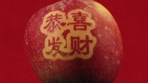 Macro full frame CU: Rotating Fortune Fuji apple with Chinese script Stock Footage 331290013