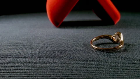 MACRO: Gift box with a golden ring fall on a surface - Slow motion Видео 145825568
