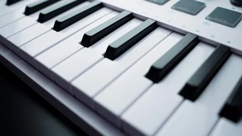 Macro glide along MIDI controller piano keys with soft bokeh and clean white Stock Footage 331112346