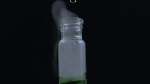 Macro green bubbling smokey liquid in vial  on black BG Stock Footage 70706094