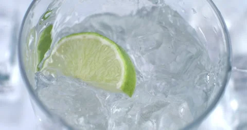Macro of green lime lemon fruit slice falling in transparent glass with water Stock Footage 268802840