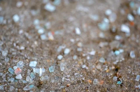 Macro ground level closeup view of rock salt ice-melt on concrete with a frozen Stock Photos