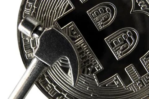 Macro. Hammer on the front side of the silver bitcoin. Close-up. Stock Photos