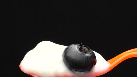 Macro Hand Placing Blueberry on Spoon of Yogurt Isolated Black Background 4K Stock-Footage 320656975