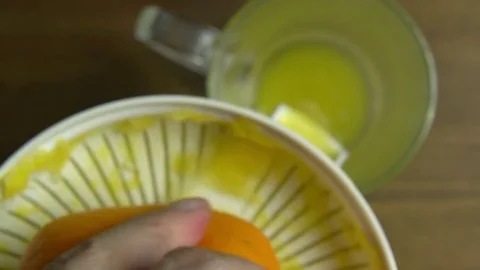 Macro Hand with Squeezer Squeezing Orange Juice Top View, Slider Video stock 76521757