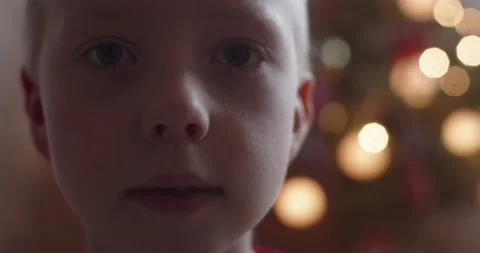 Macro handheld portrait of young boy looking seriously to camera on shallow Stock Footage 149764065