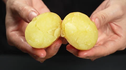 Macro Hands Breaking Hot Steamed Potato with Steam Rising Video stock 343946390