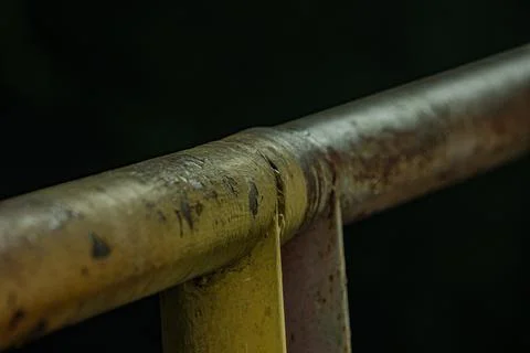 Macro of heavy rust texture on industrial iron railing steel pipe at nigh Фото