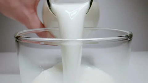 MACRO: Human pouring milk from a bottle, slow motion Stock Footage 145825775