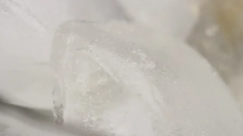 Macro ice cube as brown soda pours in and surrounds ice cube with carbonation Stock Footage 127594017
