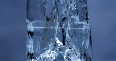 Macro of ice cubes falling in transparent glass with pure water Video stock 269383170